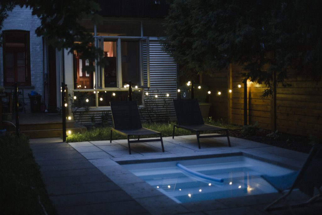 Backyard with swimming pool at night